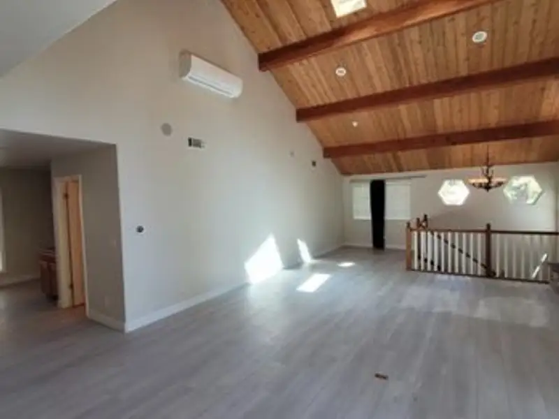 Open-plan living space with freshly painted vaulted ceiling