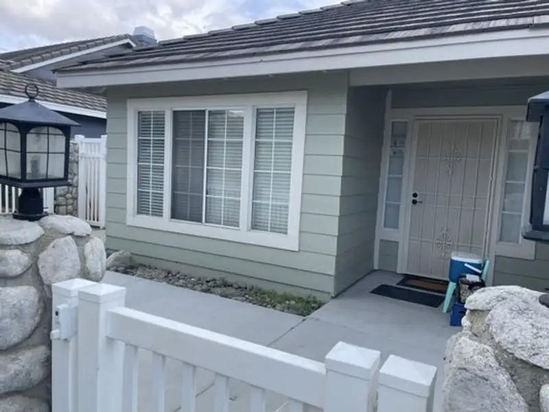 Home exterior repaint with stone accents and gated entry